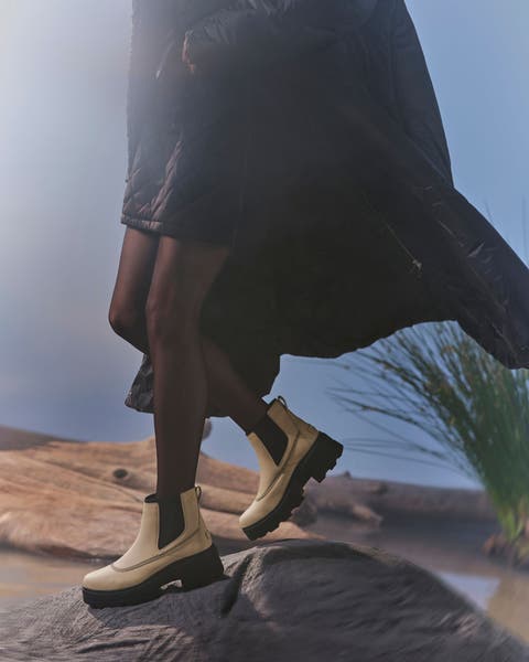 A woman wearing white Chelsea boots.