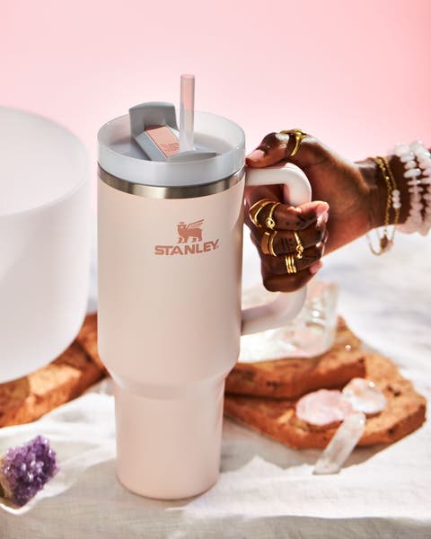 A hand holding a Stanley cup.