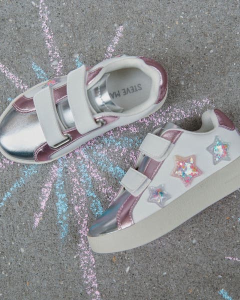 A pair of white sneakers with holographic star details.