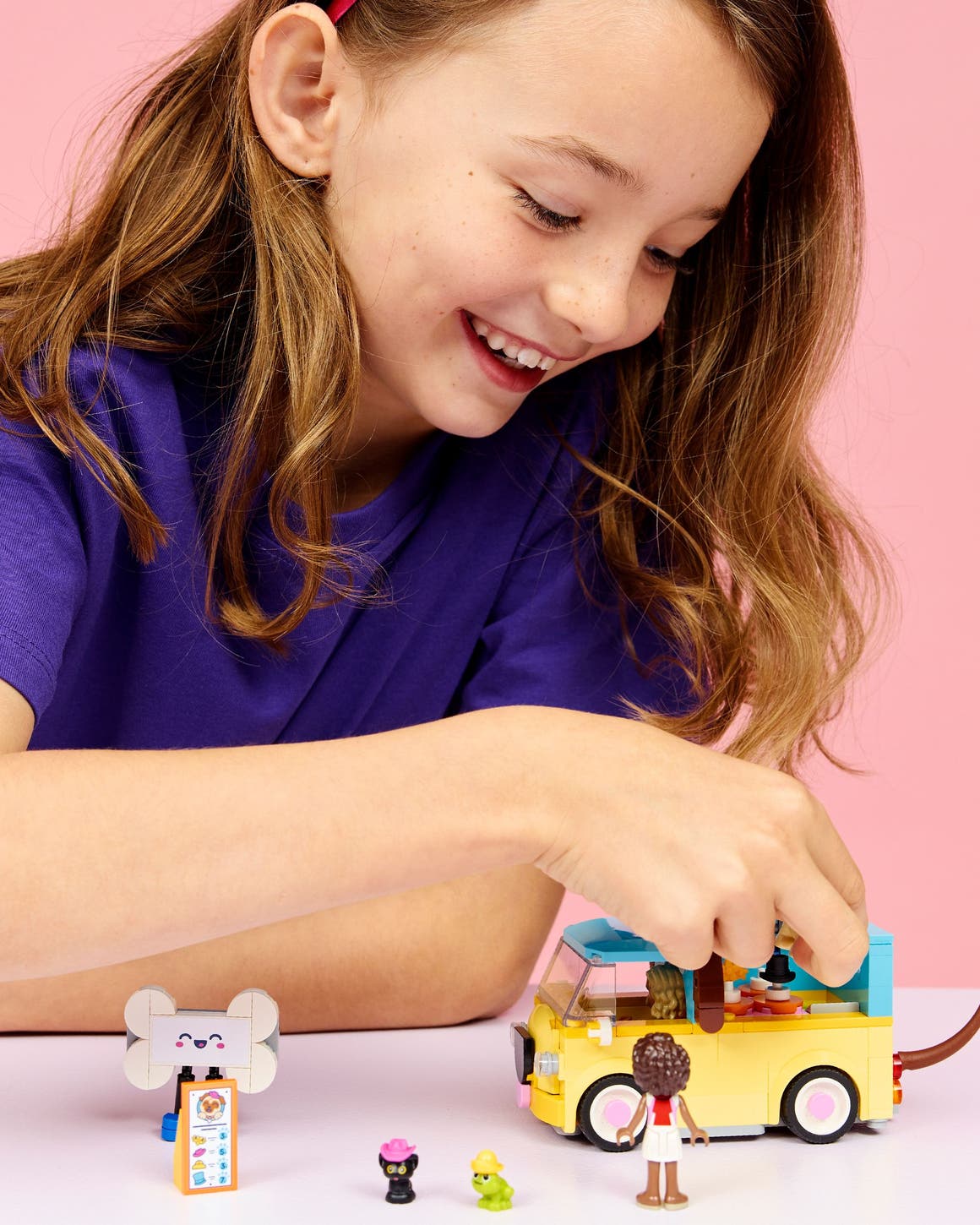 A girl playing with a LEGO set.