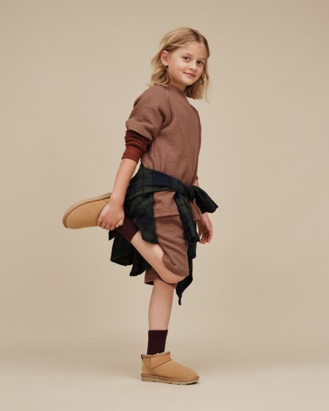 Little girl wearing UGG classic mini boots