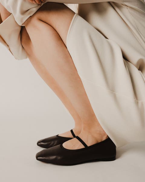 A woman wearing black mary janes.