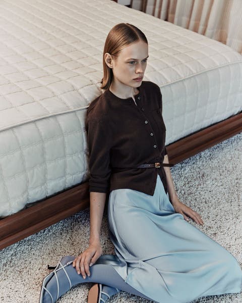 Woman wearing blue satin Vince skirt.