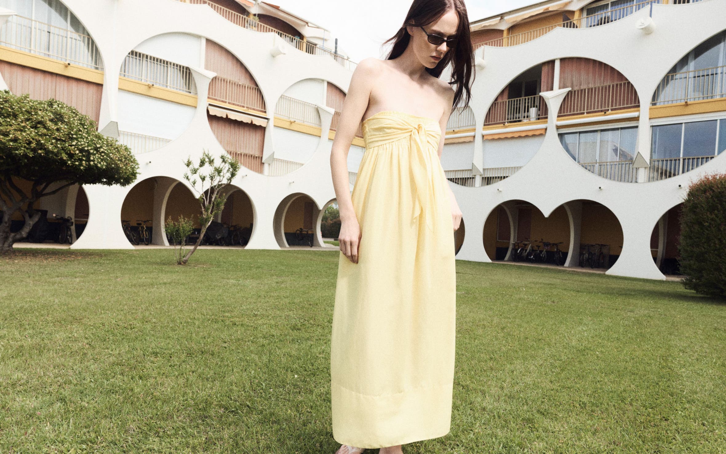 Woman wearing a yellow Vince dress.
