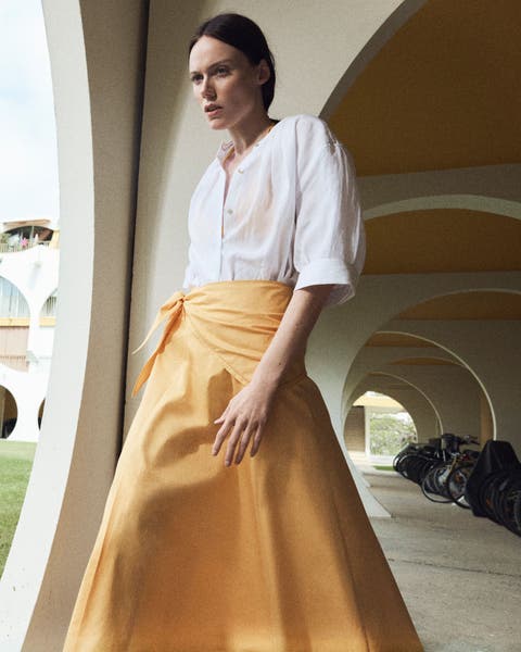 Woman wearing an orange Vince skirt.