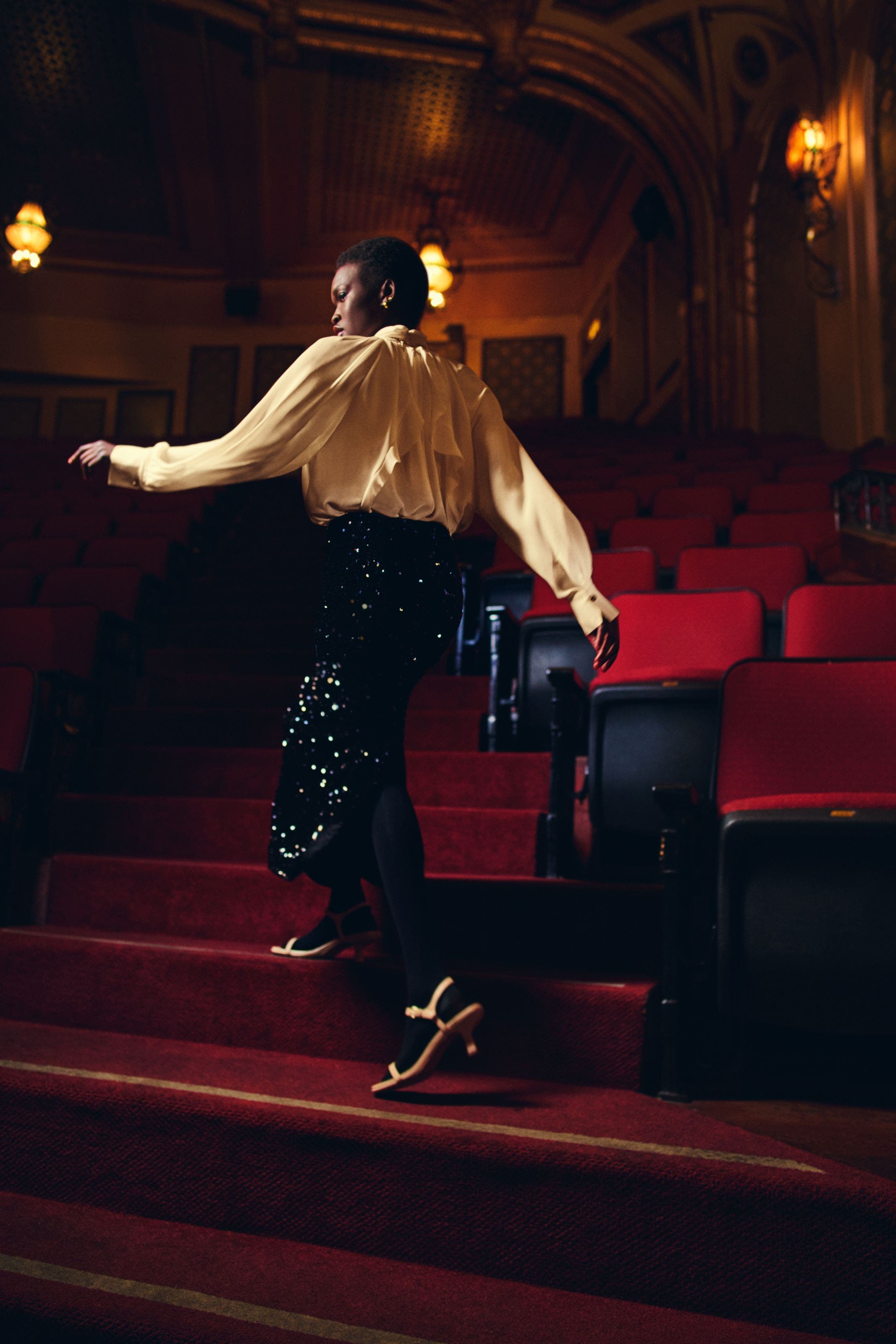 Woman wearing sequin Vince pants and white blouse.