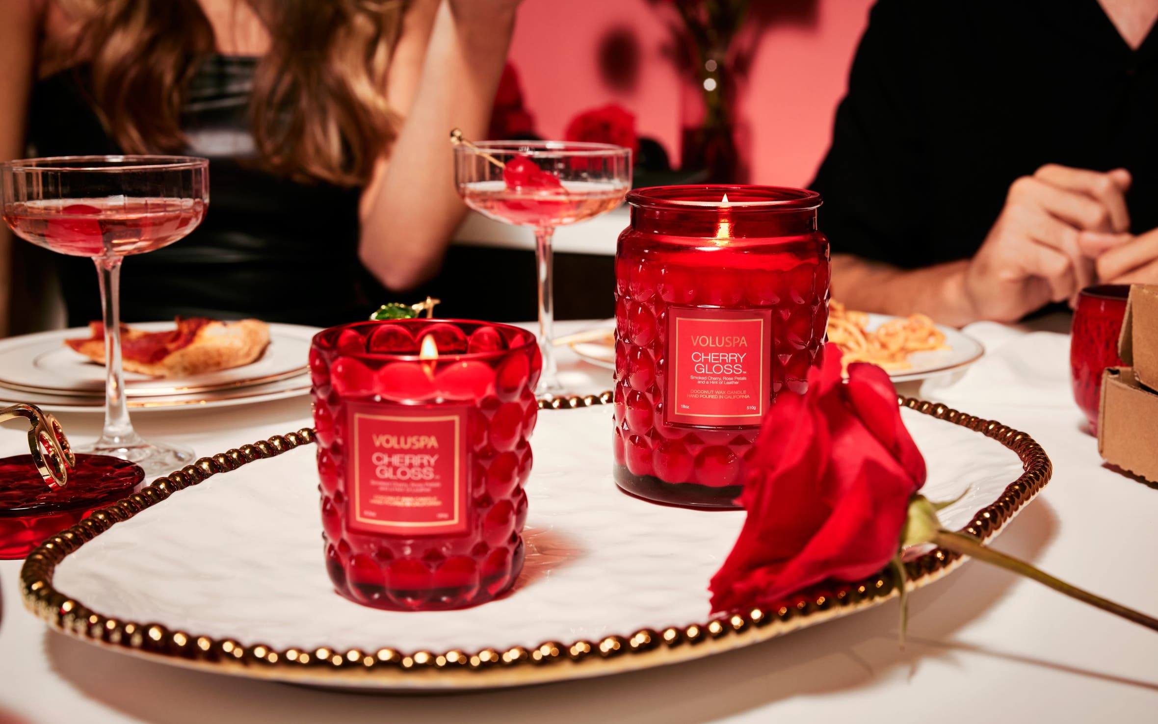 Two red Voluspa Cherry Gloss candles.