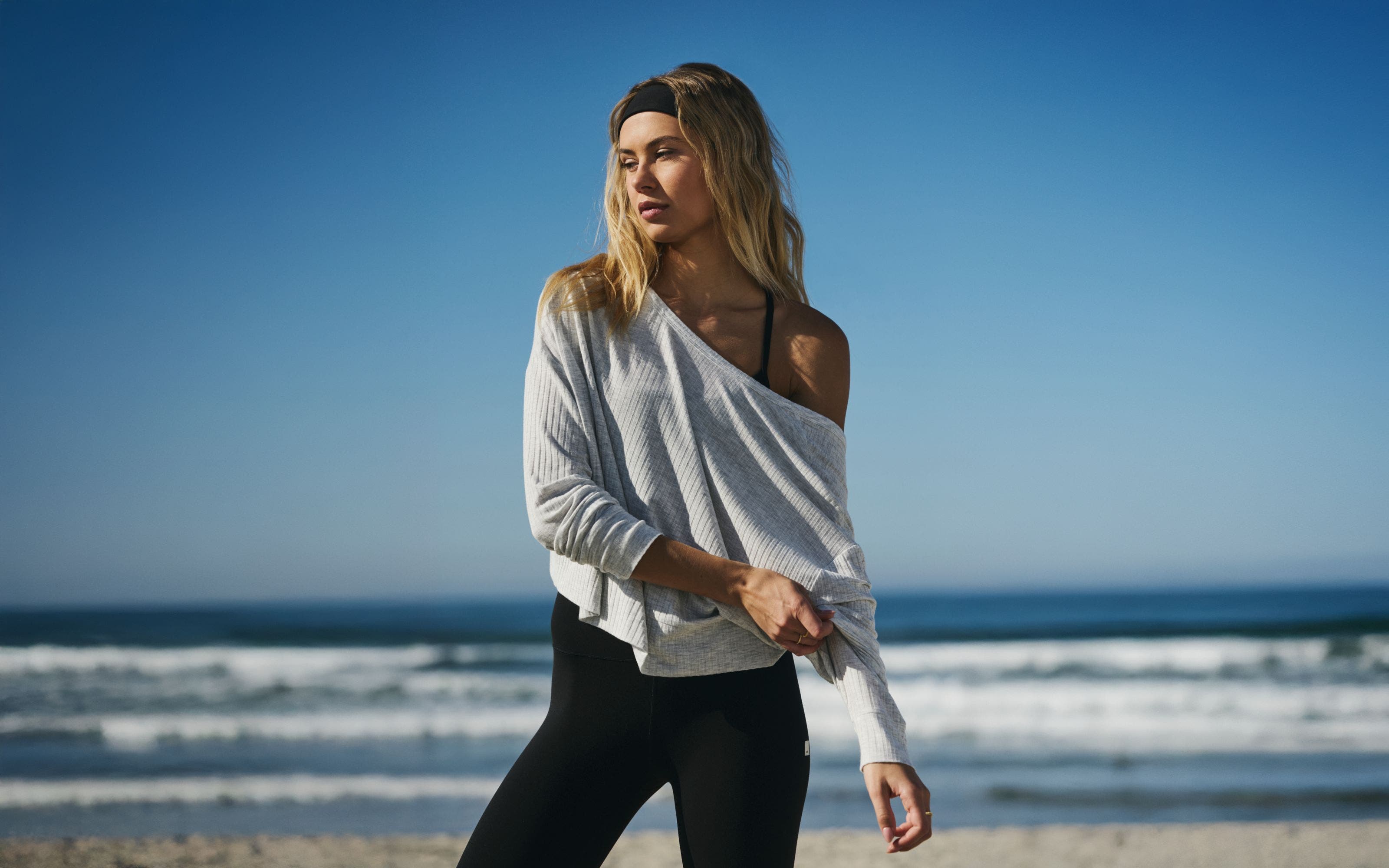 A woman wearing a long-sleeve top with leggings.
