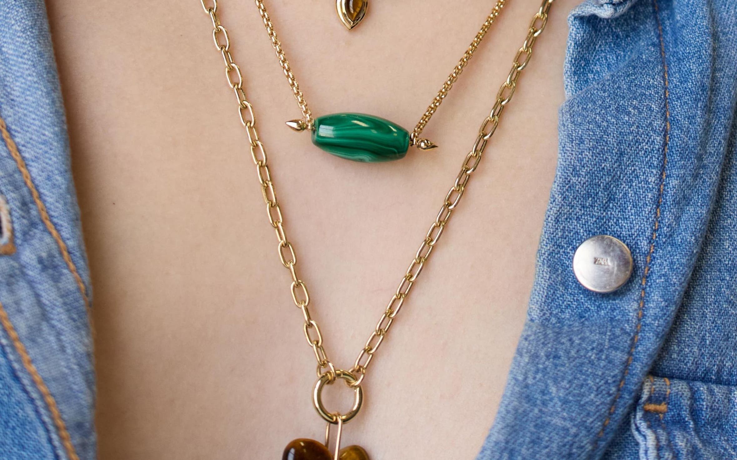 A woman wearing several necklaces.