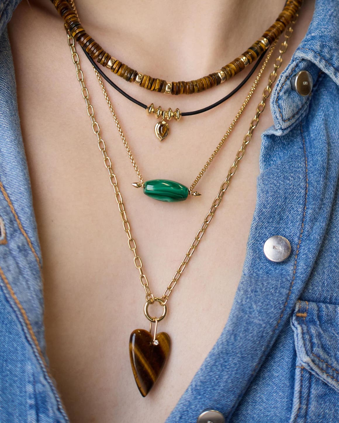 A woman wearing several necklaces.