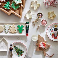 Serving trays and plates with Christmas cookies and cookie cutters.
