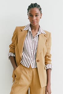 A woman wearing a striped button-up shirt with a suit. 
