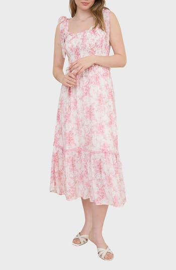 A woman wearing a pink and white floral dress