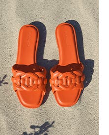A pair of orange slide sandals.