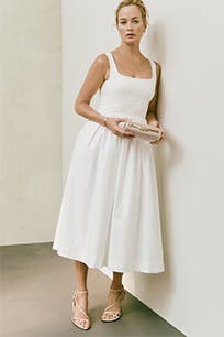 A woman wearing a white A-line dress.