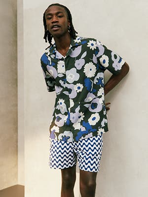Man wearing patterned shirt and shorts.