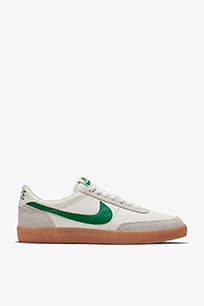 White leather sneaker with green swoosh.