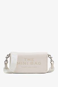 A cream crossbody bag with debossed lettering. 